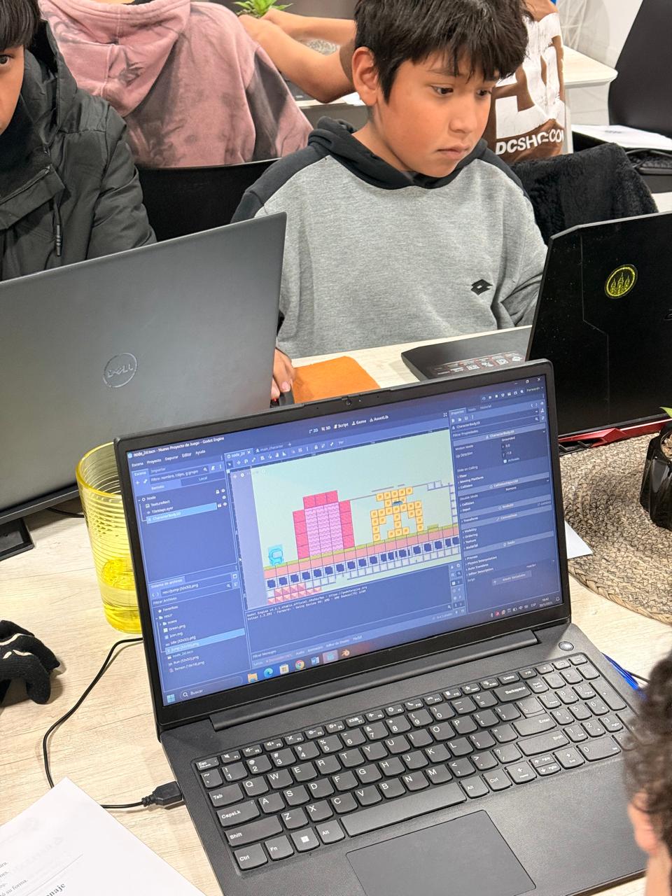 Grupo de alumnos programando con laptops